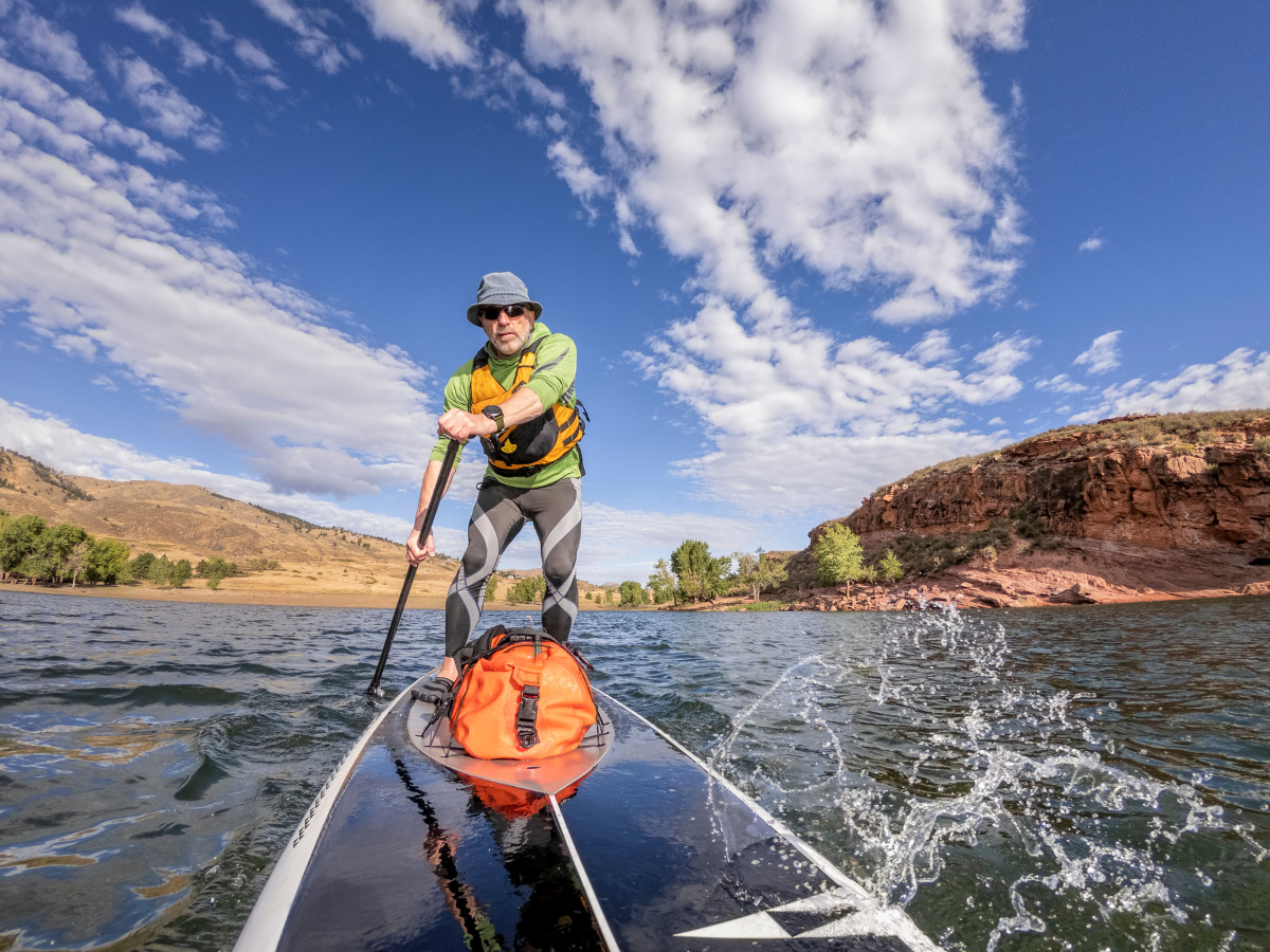 Mann auf dem Sup auf einem Fluss